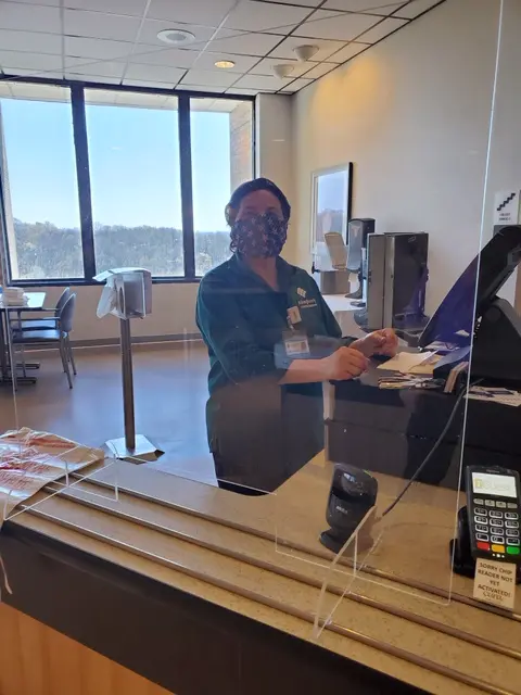 Cashier behind plexiglass
