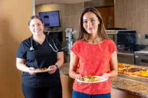 Customers smiling while holding plate of food
