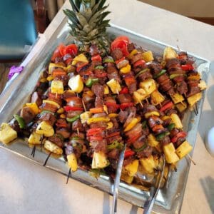 Brazilian kebobs with steak, sausage, and a variety of peppers with fresh pineapple