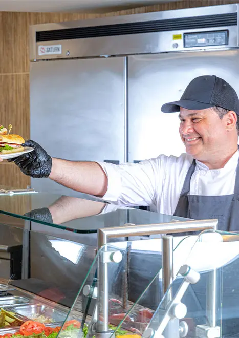 Cook handing sandwich to customer